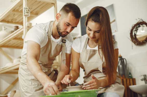 mutual-creative-work-young-beautiful-couple-casual-clothes-aprons-people-creating-bowl-pottery-wheel-clay-studio-(1)-1