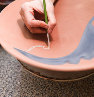 potter-woman-paints-ceramic-plate-closeup-1